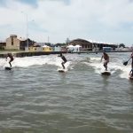Surfistas aproveitam a pororoca no Rio Tramandaí com a ressaca do mar