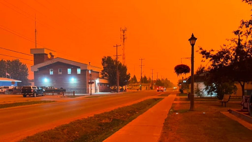 Incêndios tornam céu laranja no Canadá e milhares fogem por terra e ar