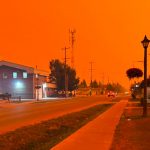 Incêndios tornam céu laranja no Canadá e milhares fogem por terra e ar