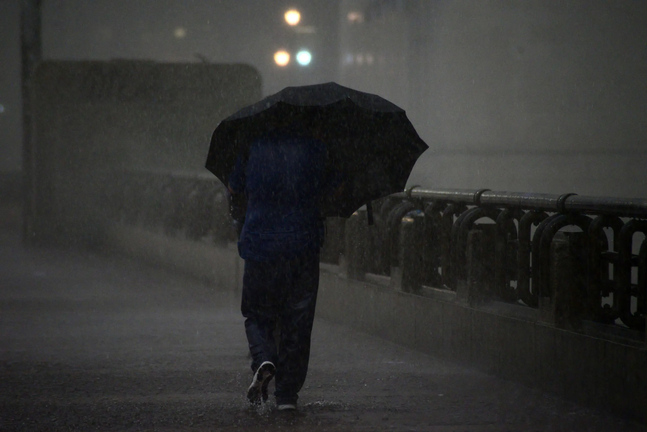 Foto mostra homem com guarda-chuva em São Paulo 