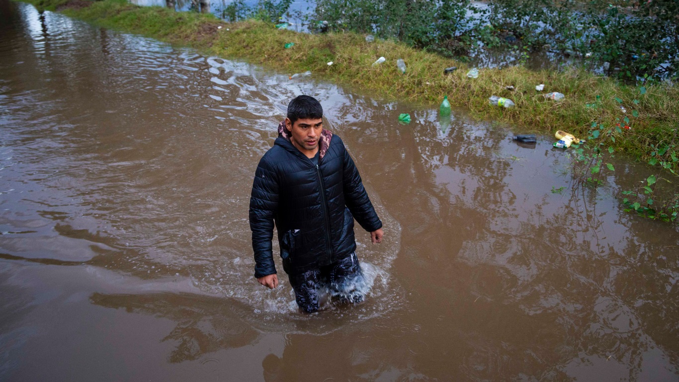 Foto mostra homem caminhando em área inundada na enchente da Argentina Foto mostra homem caminhando em área inundada na enchente da Argentina