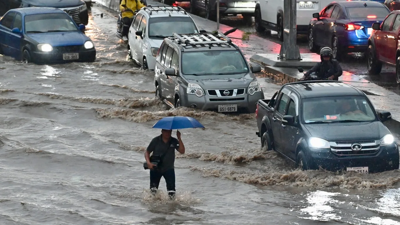 Homem caminha por área alagada após fortes chuvas no Norte de Guayaquil 